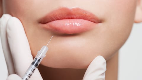 Mujer aplicándose bótox en el rostro.
