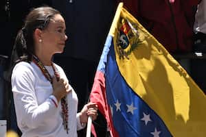 La líder de la oposición venezolana María Corina Machado sostiene una bandera nacional venezolana mientras hace gestos desde lo alto de un camión durante una manifestación para protestar por los resultados de las elecciones presidenciales, en Caracas el 3 de agosto de 2024. Venezuela se preparó para nuevas protestas después de que la disputada victoria electoral del presidente Nicolás Maduro fuera ratificado en la víspera, y un número creciente de naciones reconocieron a su rival de la oposición como el verdadero ganador. (Foto de Juan BARRETO/AFP)