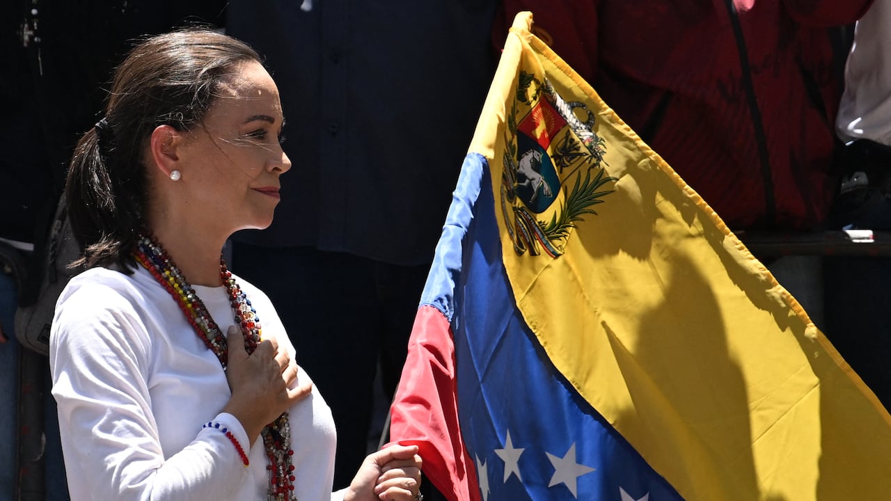 La líder de la oposición venezolana María Corina Machado sostiene una bandera nacional venezolana mientras hace gestos desde lo alto de un camión durante una manifestación para protestar por los resultados de las elecciones presidenciales, en Caracas el 3 de agosto de 2024. Venezuela se preparó para nuevas protestas después de que la disputada victoria electoral del presidente Nicolás Maduro fuera ratificado en la víspera, y un número creciente de naciones reconocieron a su rival de la oposición como el verdadero ganador. (Foto de Juan BARRETO/AFP)