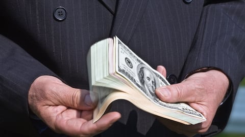 Businessman fanning through a handful of dollar