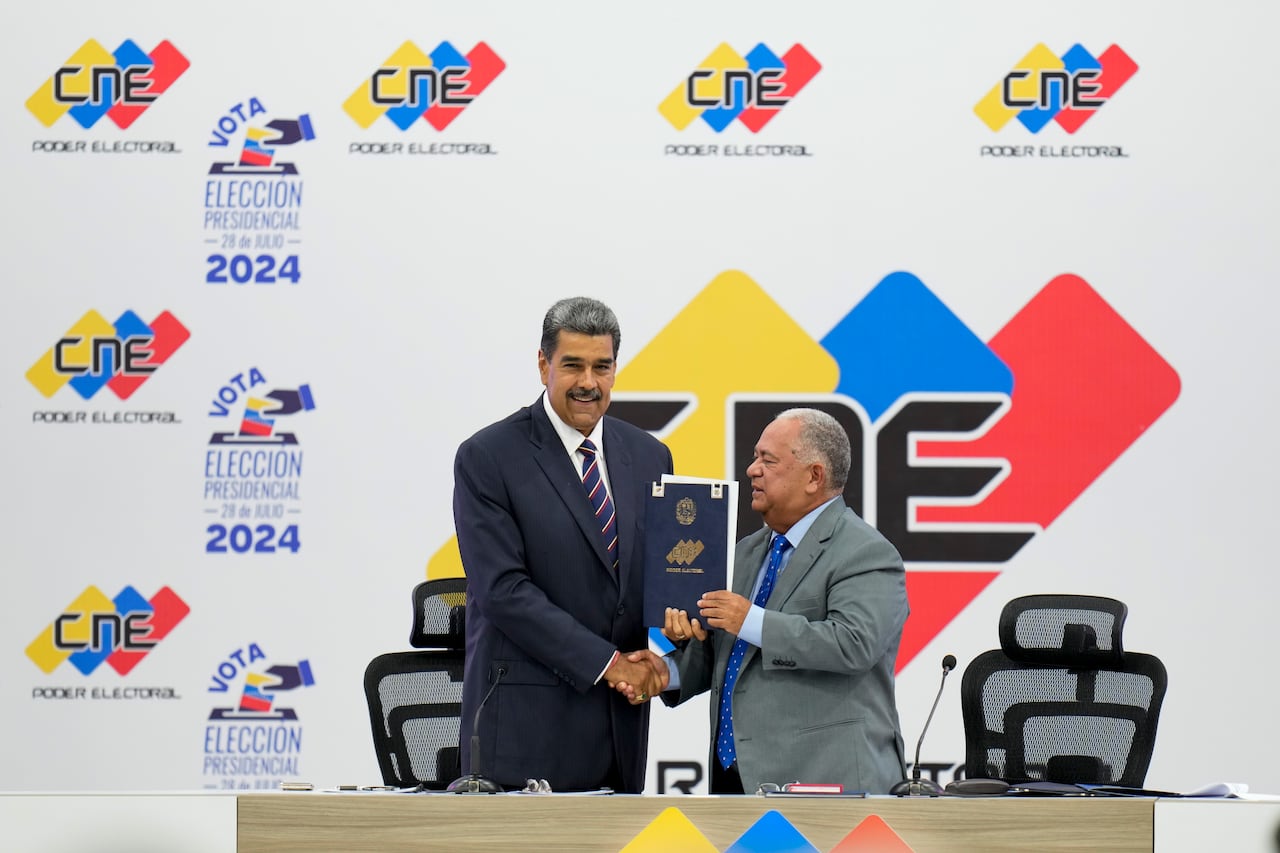 El presidente venezolano Nicolás Maduro, a la izquierda, recibe la certificación del presidente del Consejo Nacional Electoral (CNE), Elvis Amoroso, de que ganó las elecciones presidenciales en Caracas, Venezuela, el lunes 29 de julio de 2024. (AP Foto/Matías Delacroix)