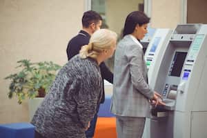 Senior woman trying to see pin number over shoulder
